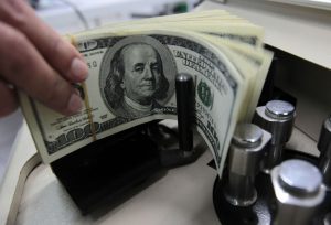 Dólar interrompe série negativa sob influência externa e retorna aos R$5