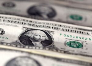 Dólar sobe pelo 3º dia influenciado por commodities e se reaproxima de R$5